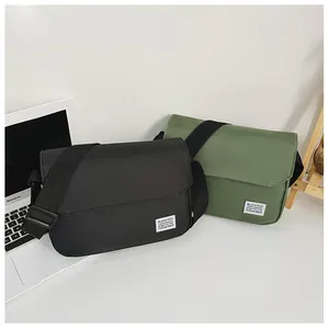 Detail of minimalist black and olive green messenger bags with adjustable straps