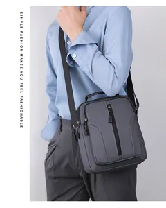 Detail van grijze waterdichte crossbodytas met meerdere ritszakken en verstelbare riem
