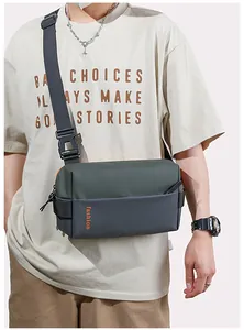 Detail of trendy men's crossbody bag featuring green and grey patchwork with fashion text