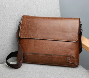 Detail view of vintage brown leather briefcase on a sofa highlighting texture and strap