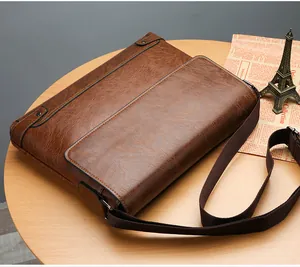 Close-up of vintage brown leather briefcase with adjustable strap and metal hardware