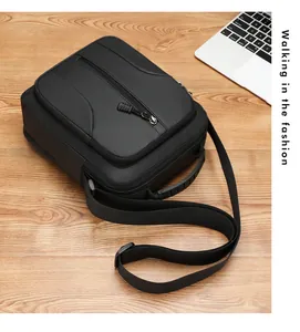 Detail van waterdichte nylon borsttas met ritsen op een houten bureau met een laptop