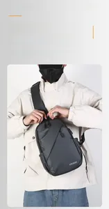 Détail du tissu imperméable et des multiples poches zippées d'un sac bandoulière gris moderne