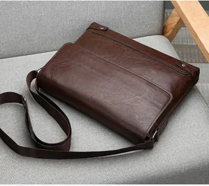 Close-up of a vintage dark brown leather briefcase on a chair showing texture and buckles