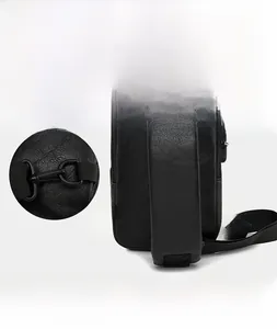 Detail of adjustable D-ring shoulder strap buckle on black leather crossbody chest bag