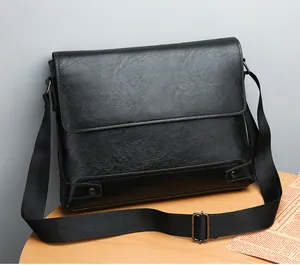 Detail of black faux leather messenger bag with adjustable strap and metallic rivets decoration