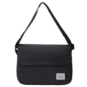 Minimalist black canvas messenger bag with adjustable strap and flap cover design