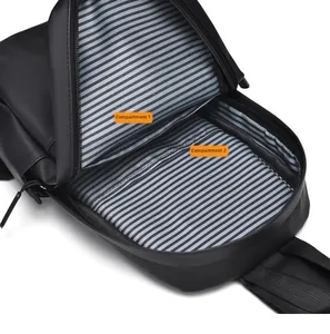Detail of the dual-compartment interior with blue and white striped lining in a black chest bag