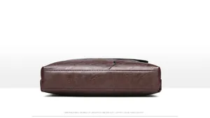 Détails de la base et des coutures d'un sac bandoulière en cuir marron foncé pour homme