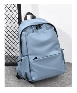 Detail view of large-capacity foggy blue nylon backpack with side pockets on grey carpet