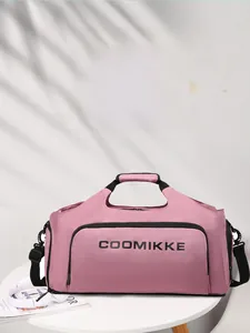 Détail du sac de sport rose en nylon avec logo de marque sur une table blanche épurée