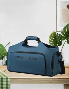 Sac de voyage bleu sur table bois adapté pour ordinateur 15,6 pouces avec bandoulière