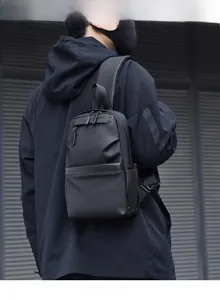 Close-up of black waterproof men's crossbody bag featuring industrial zippers and hooks