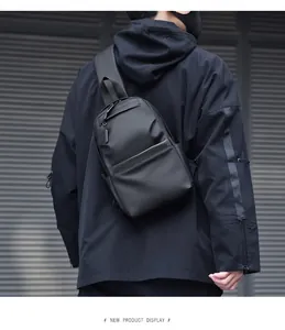 Rear view of model wearing a black waterproof crossbody sling bag in urban techwear style