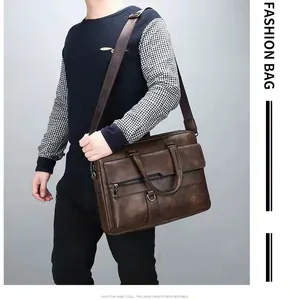 Close-up of vintage brown leather briefcase with adjustable shoulder strap and dual handles
