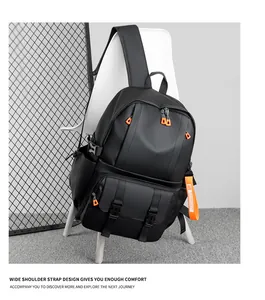 Detail of durable black nylon backpack with orange zippers and wide shoulder straps