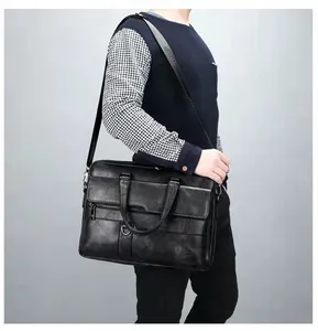Man wearing black leather briefcase featuring adjustable shoulder strap with logo detail