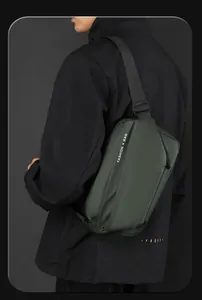 Detail of dark green crossbody bag with white FASHION BAG text and adjustable strap