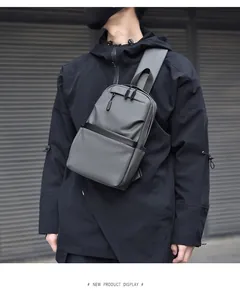 Detail of dark gray waterproof sling bag with multiple zippers and matte finish