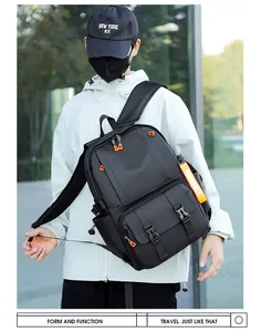 Detail of a black waterproof backpack featuring vibrant orange zipper pulls and side straps