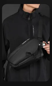 Detail view of the black crossbody chest bag featuring a functional side mesh water bottle pocket