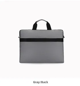 Rear view of grey waterproof laptop bag featuring a black luggage trolley strap for travel