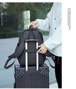 Detail of black travel backpack showing the luggage strap secured to a trolley handle