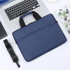 Maletín para portátil azul oscuro textura denim con asa negra y correa de hombro ajustable