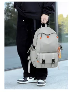 Detail of grey waterproof nylon backpack with orange zippers and buckle closures
