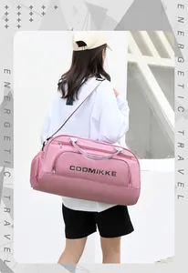 Pink travel duffel bag with shoe compartment shown being carried by a model outdoors