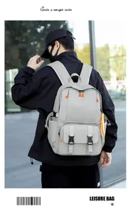 Outdoor lifestyle shot of a grey large capacity backpack with orange accents