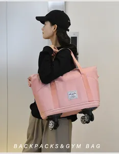 Détail du sac de voyage rose montrant les roues pivotantes et la texture du nylon
