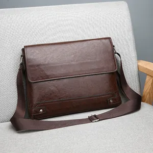 Vintage dark brown men's business briefcase in textured leather on a sofa