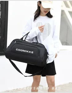 Close-up of black gym bag with COOMIKKE logo featuring sturdy handles and adjustable strap