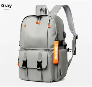 Close-up of grey backpack featuring external USB port and orange fashion zipper details