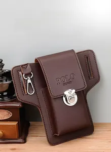 Brown leather waist phone bag with metal buckle and belt loop detail on a wooden desk