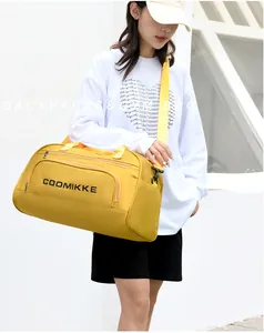 Yellow fitness travel bag with shoulder strap shown in a modern urban street setting