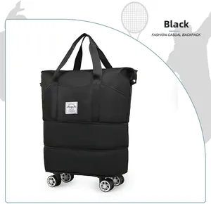 Detail view of foldable black travel bag featuring bottom swivel wheels and waterproof fabric