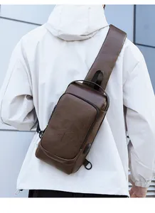 Detail of dark brown leather chest bag with USB charging port and pebbled texture
