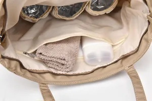 Detail view of large tote bag interior showing insulated milk bottle pockets and zipper compartment