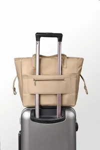Beige waterproof travel bag with suitcase sleeve and convenient zipper pocket
