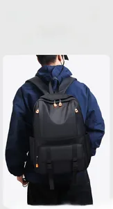 Detailansicht eines schwarzen Nylon-Rucksacks mit orangefarbenen Akzenten am männlichen Model