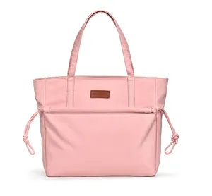 Detailed close-up of pink nylon tote bag with leather badge and drawstring details