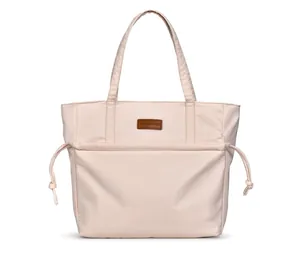 Detail of cream tote bag featuring a leather logo patch and functional side drawstrings
