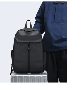 Close-up of black commuter backpack placed on a silver suitcase for business travel