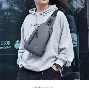 Detailed view of the dark grey waterproof crossbody bag with USB port and brand logo