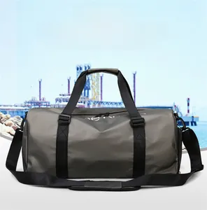 Dettaglio della borsa da viaggio impermeabile verde oliva con manici neri e tracolla