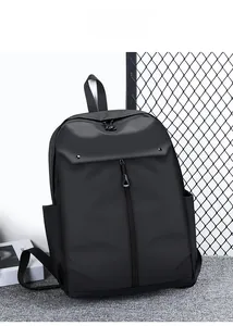 Modern black business backpack on a grey carpet showing sleek front zip and side pockets