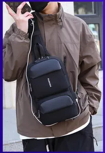 Detail der Herren Brusttasche in Schwarz mit USB-Ladeanschluss und Anti-Diebstahl-Schloss