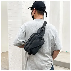 Detailed side view of dark grey tactical chest bag with adjustable straps on a model